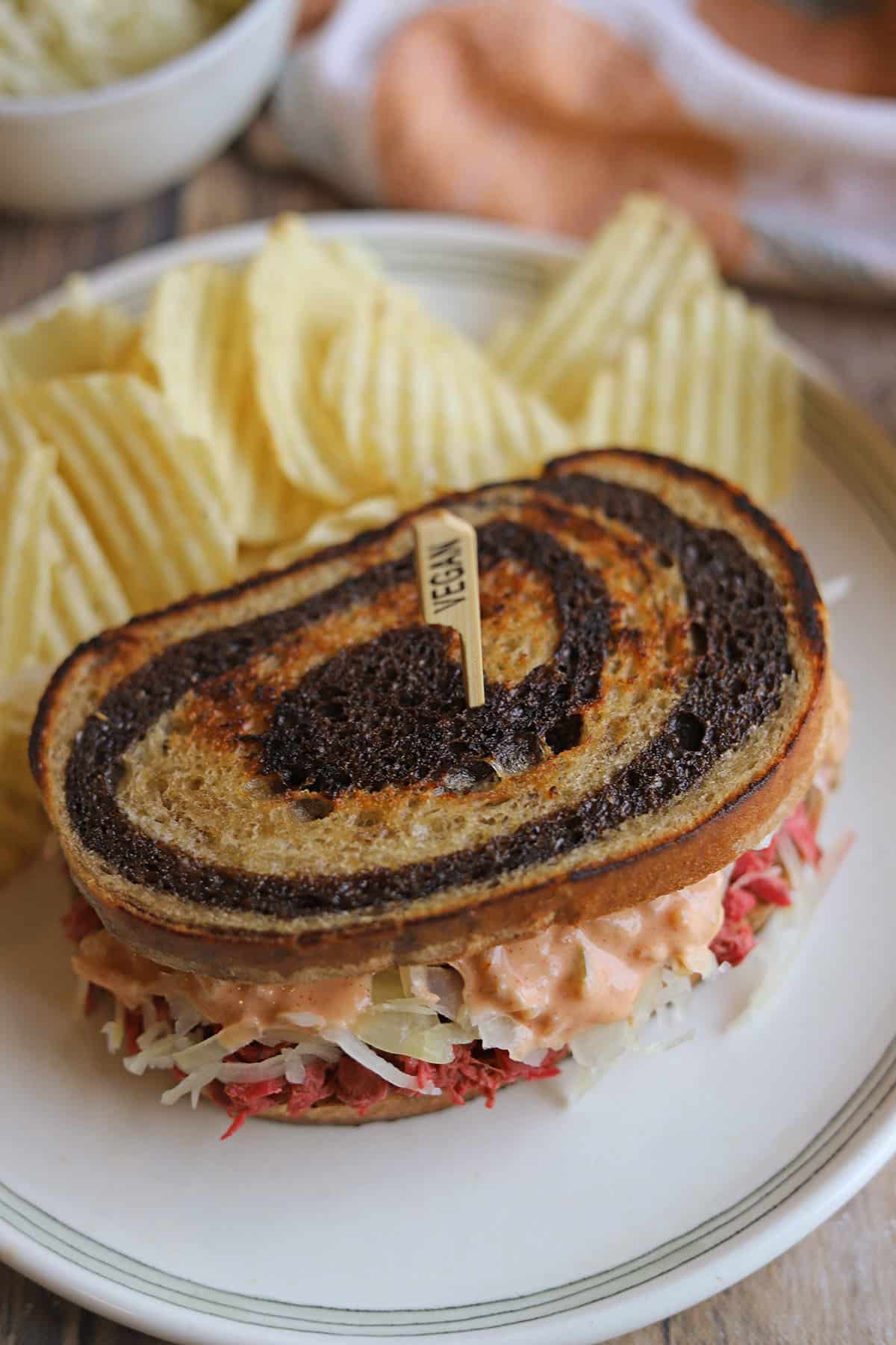 Jackfruit corned beef reuben on marbled rye with potato chips.