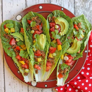 Raw tacos with walnut taco meat, sliced avocado, bell pepper, tomatoes, and green onions on platter.