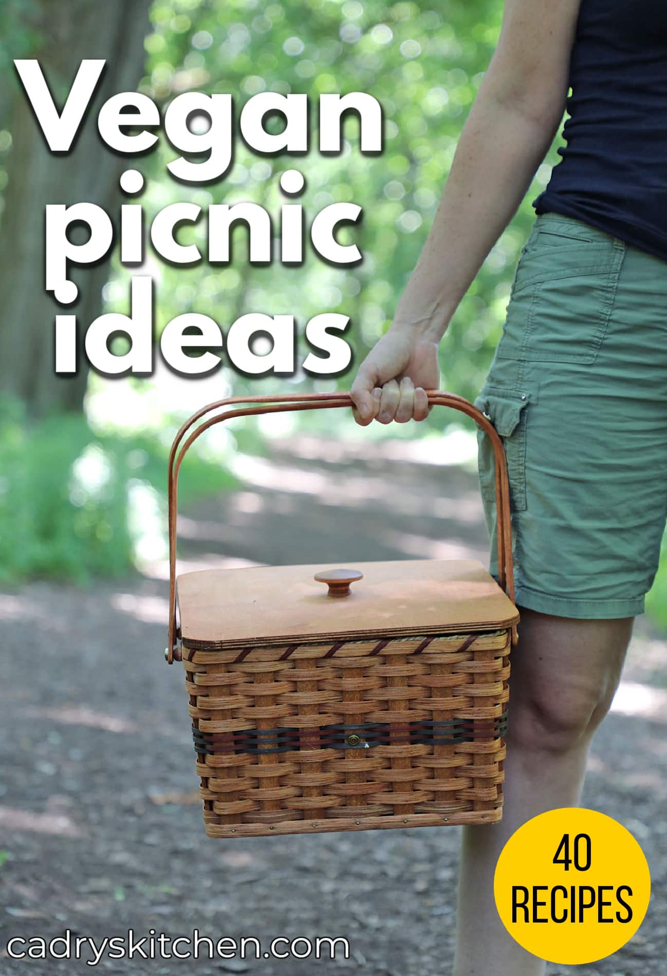 Text overlay: Vegan picnic ideas, 40 recipes, cadryskitchen.com. Hand holding picnic basket in woods.