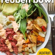 Text overlay: Vegan reuben bowl, jackfruit corned beef, cadryskitchen.com. Bowl with corned jackfruit, vegan Thousand Island dressing, sauerkraut, avocado, and salad.