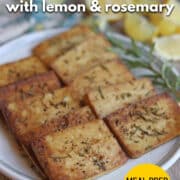 Text overlay: Baked tofu with lemon & rosemary. Meal prep favorite. cadryskitchen.com. Slabs of lemon rosemary tofu on plate.