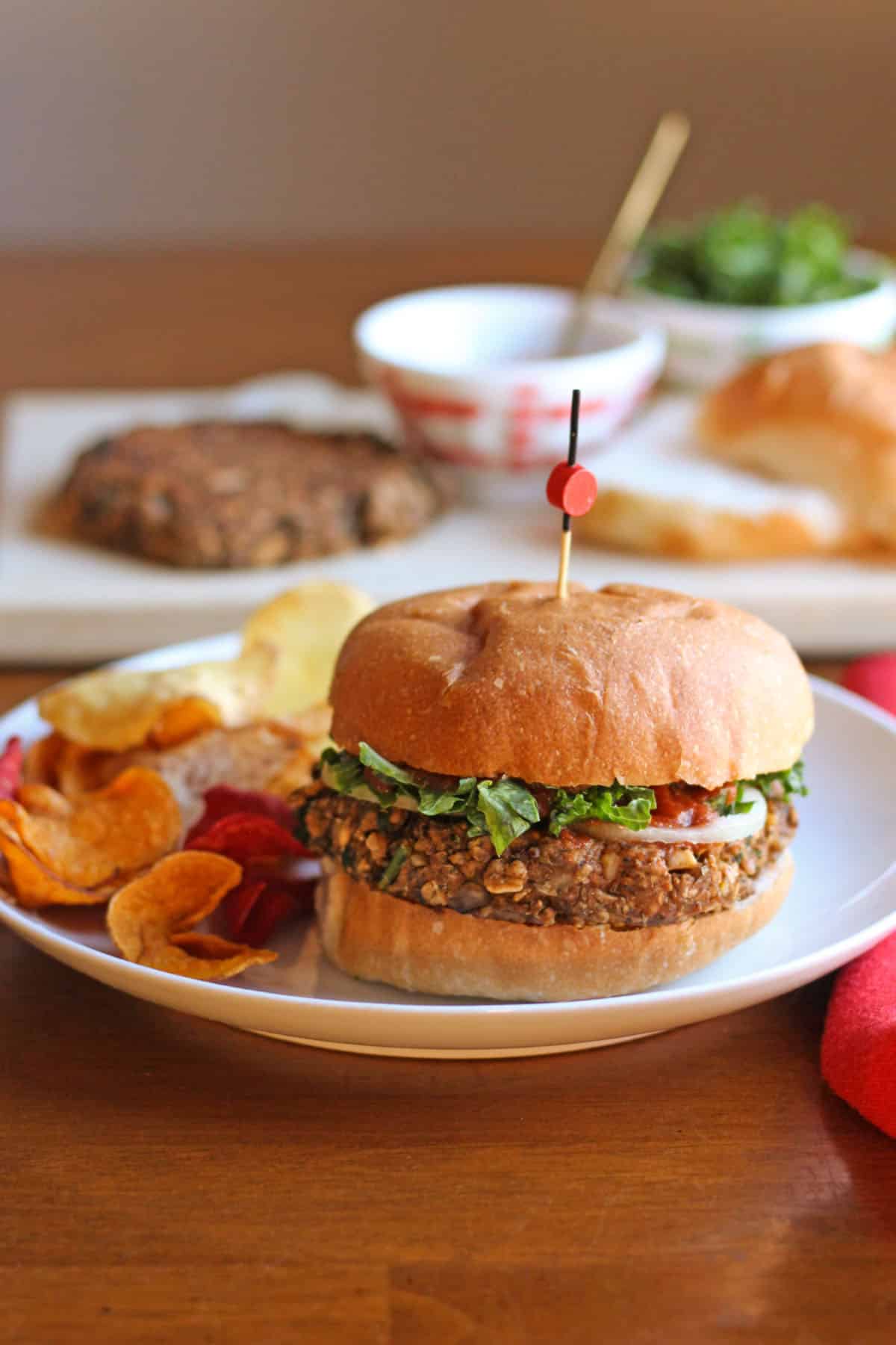 Vegan lentil burger on plate with side of chips.