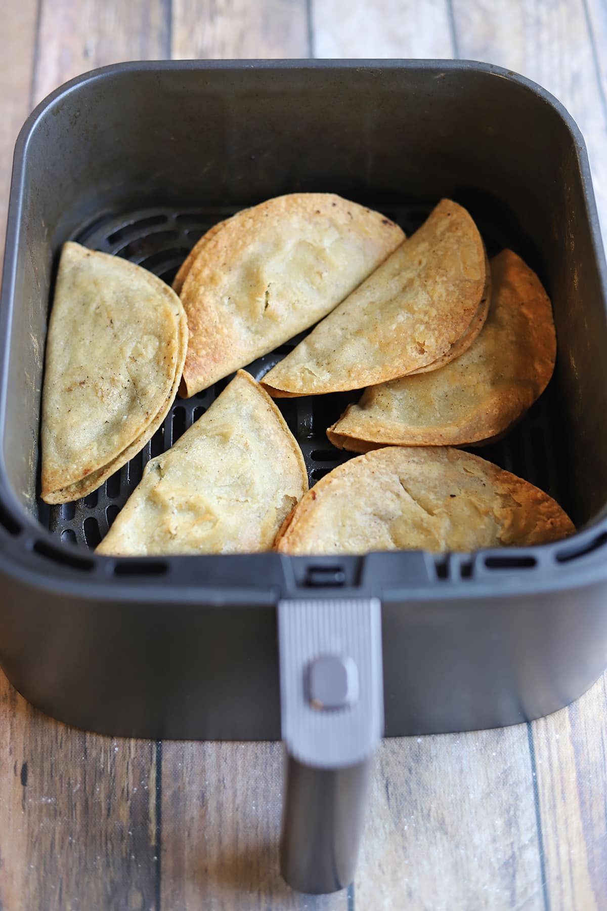Trader Joe's potato tacos in air fryer basket.