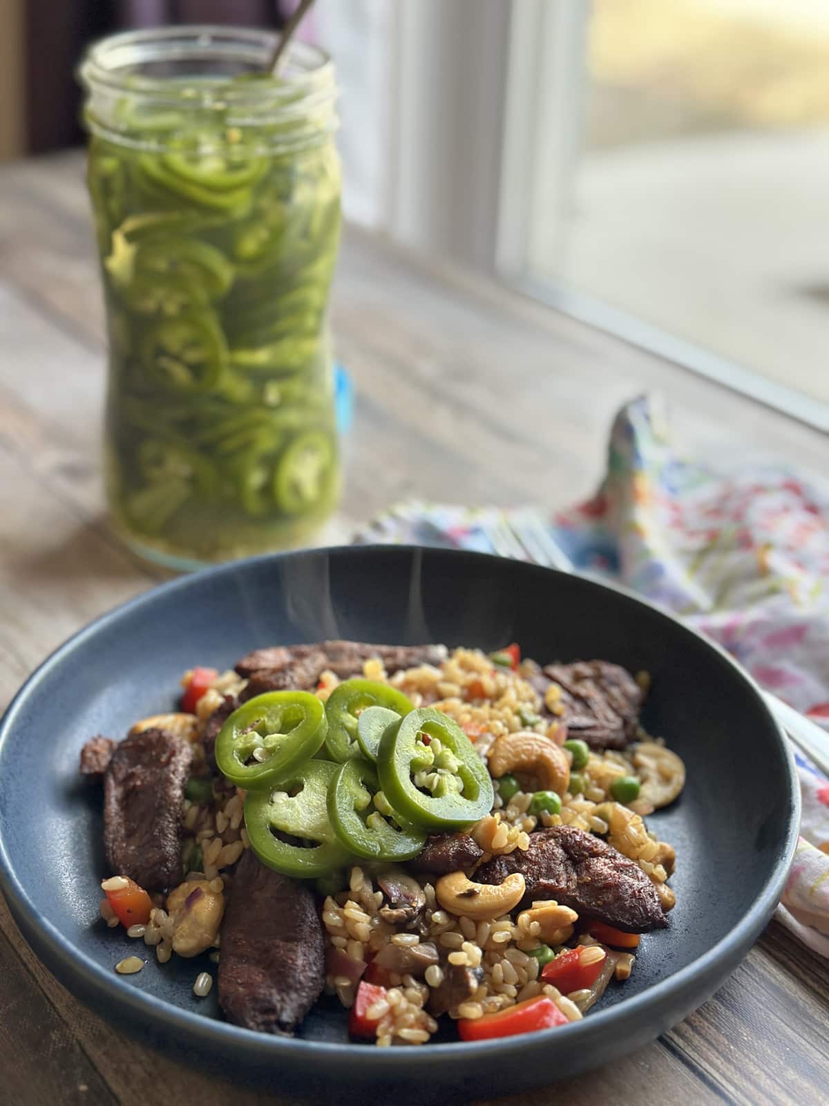 Beefless bulgogi strips in stir-fry topped with pickled jalapenos and cashews.