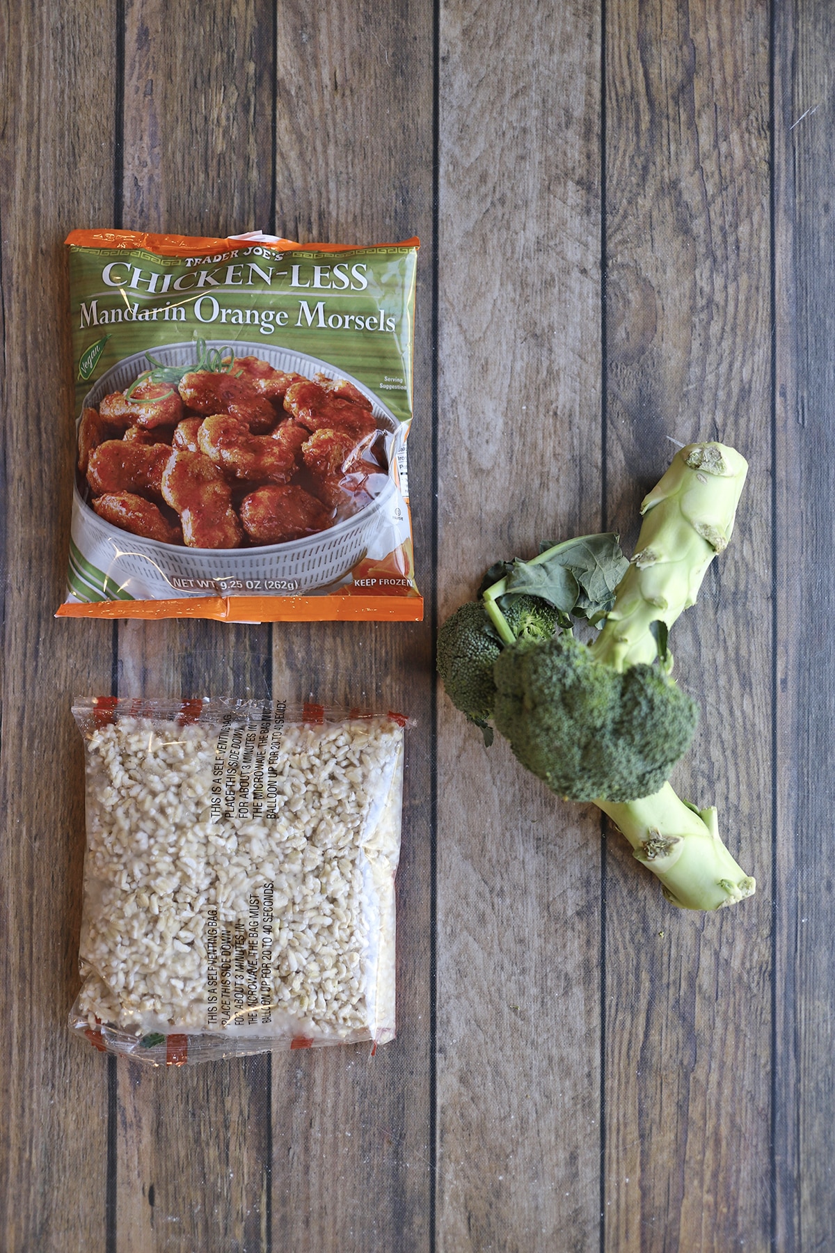 Package of Trader Joe's chicken-less Mandarin orange morsels, broccoli, and brown rice packet on table.