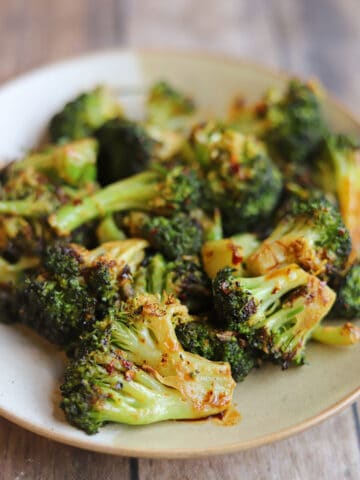 Pile of spicy broccoli with chili crisp sauce on plate.