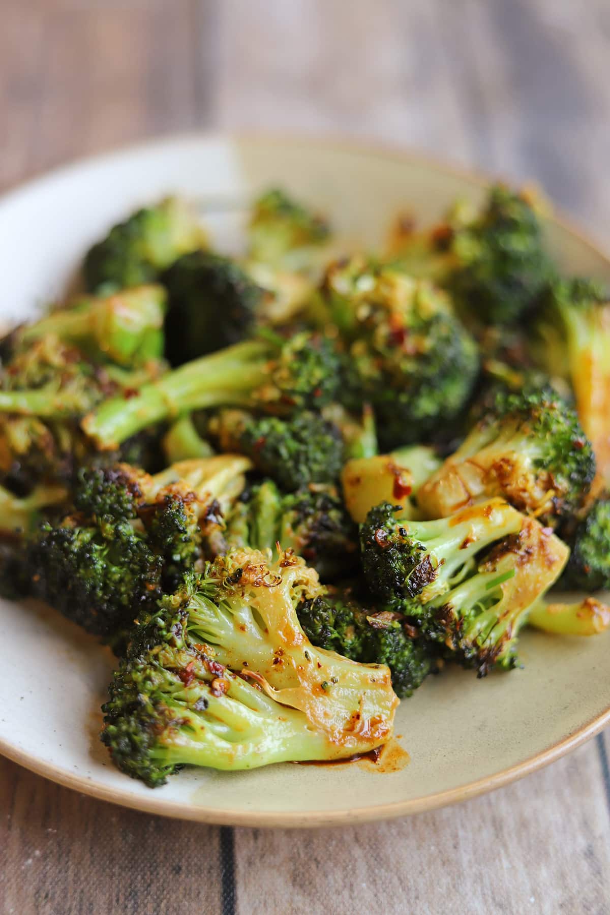 Pile of spicy broccoli with chili crisp sauce on plate.
