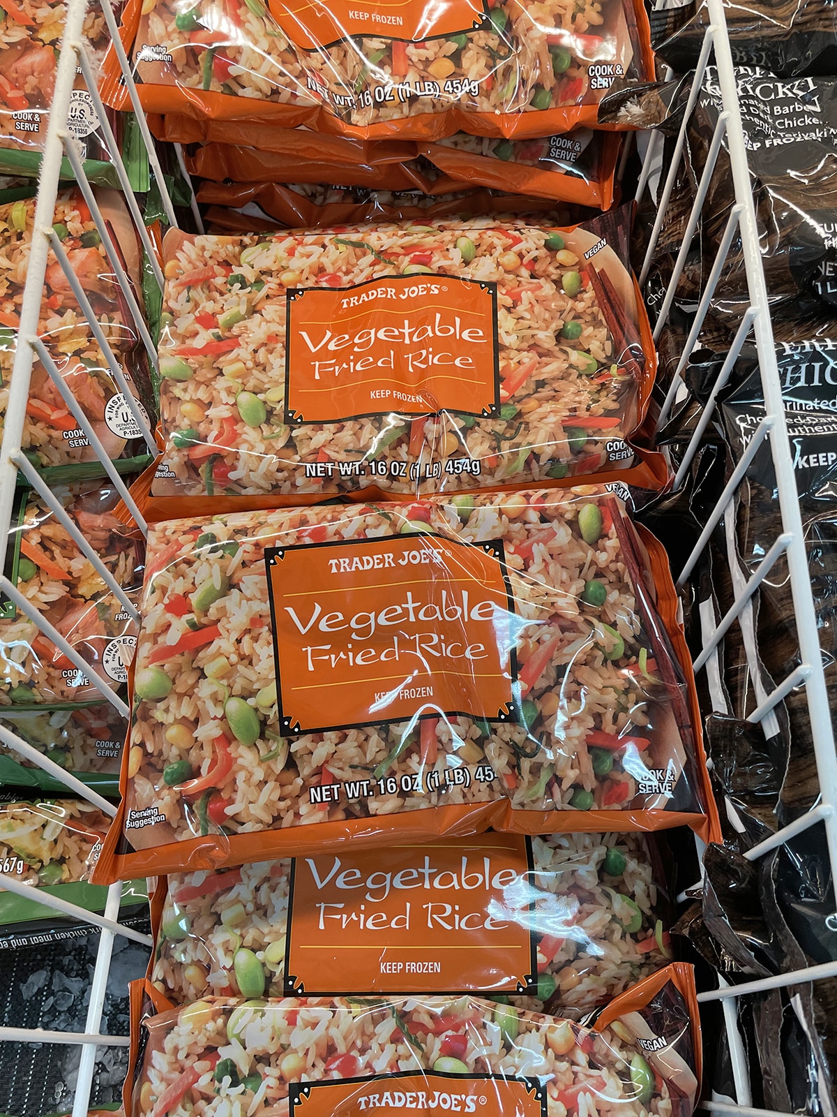 Bags of Trader Joe's vegetable fried rice in freezer section of the grocery store.