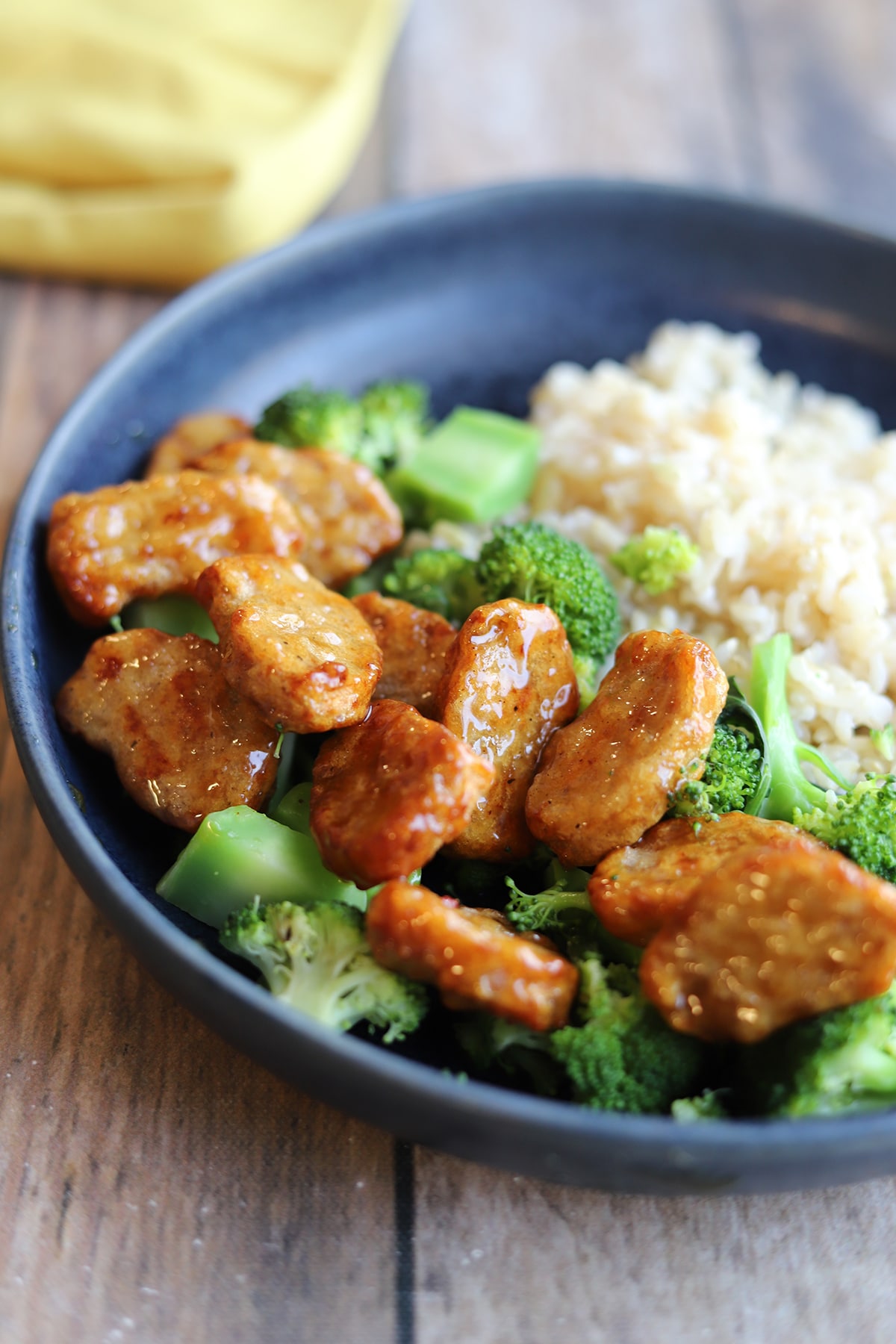 Vegan orange chicken and steamed broccoli in bowl with rice.