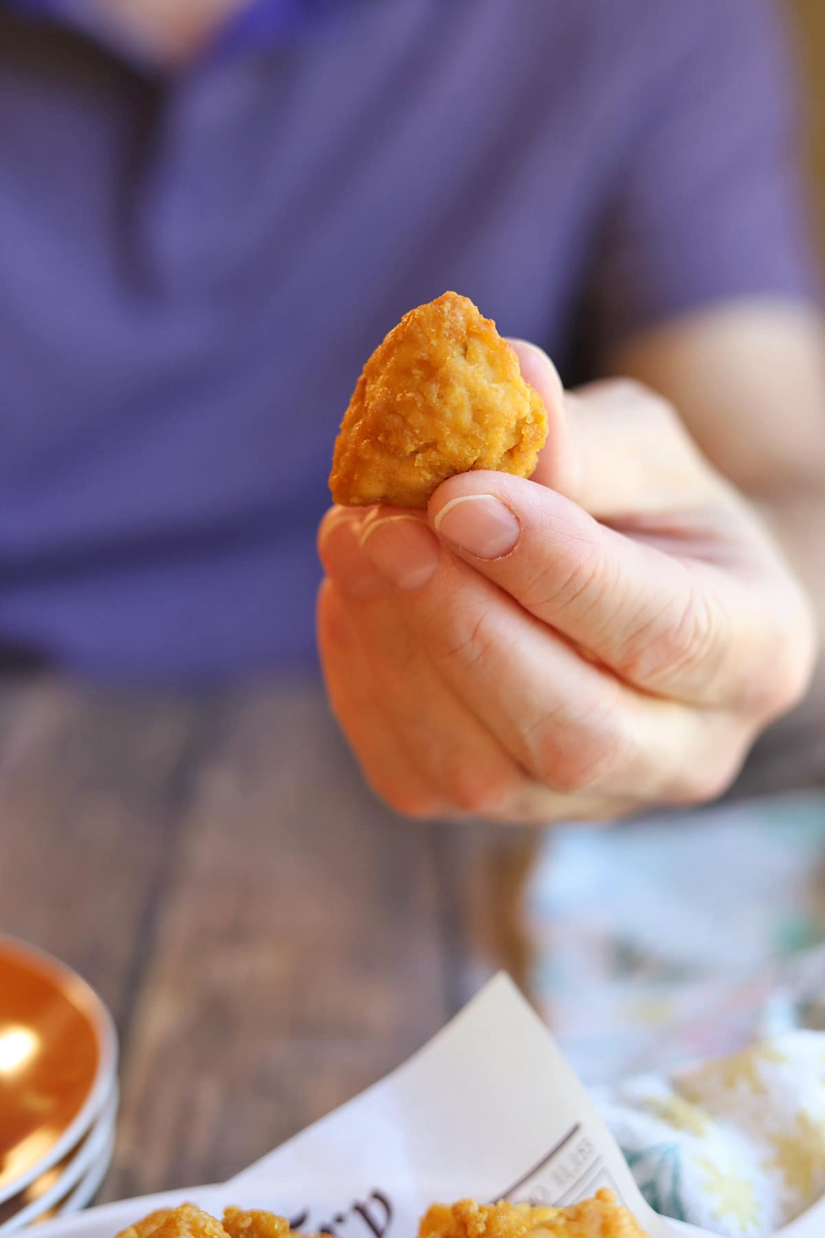 Hand holding air fryer tofu nugget.