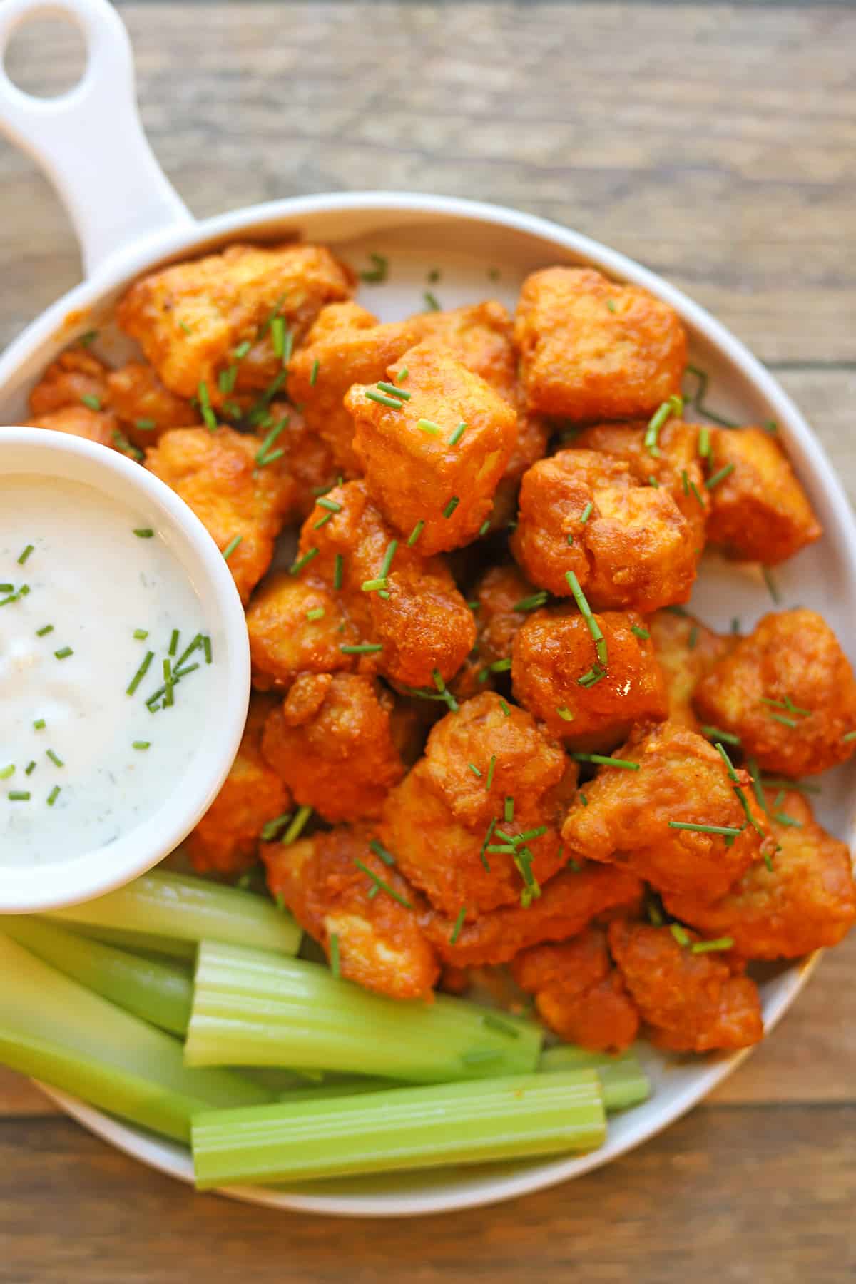 Platter of saucy vegan buffalo bites with celery and onion & garlic dressing.