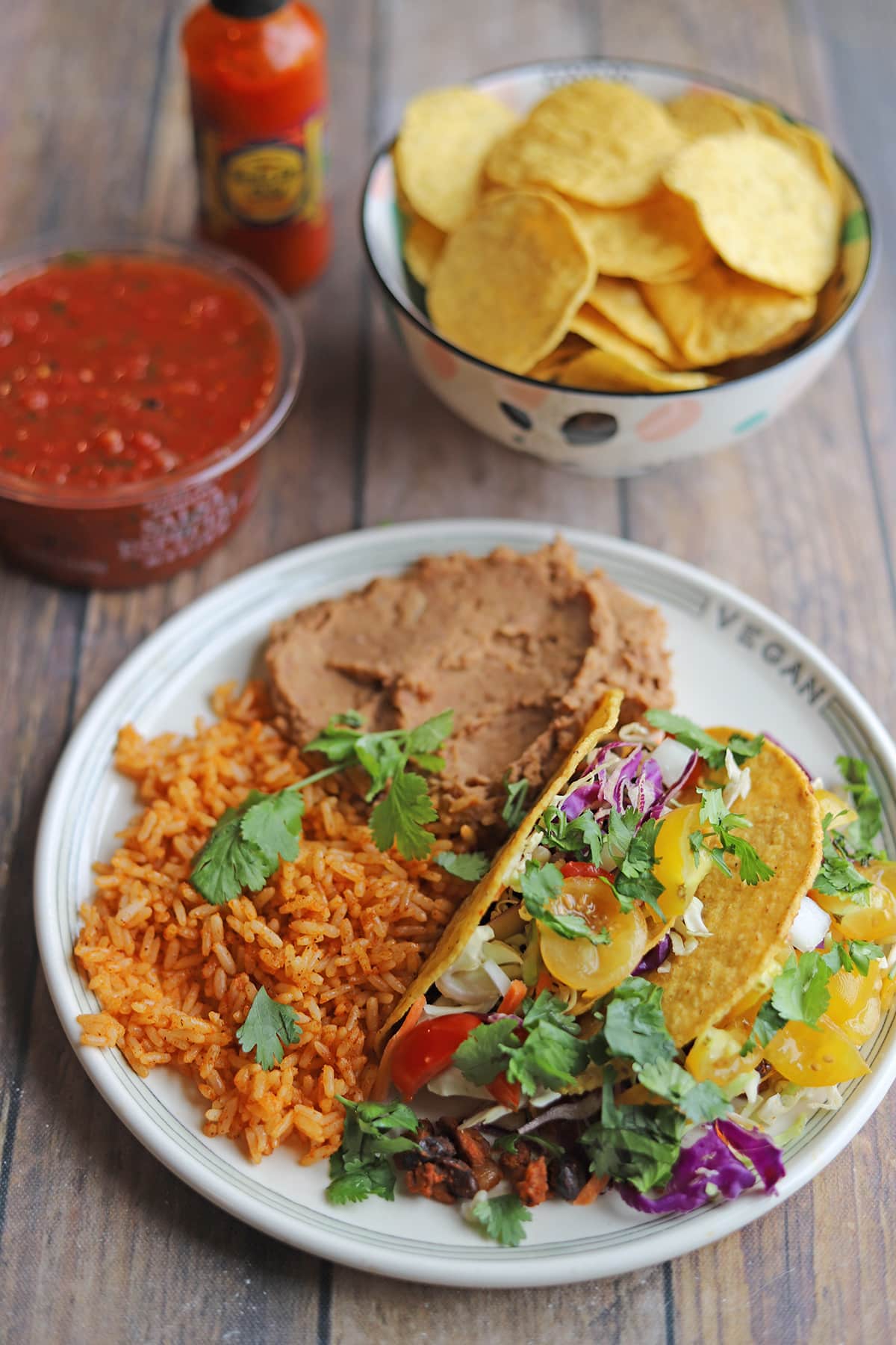 Plate of tacos in hard shell, rice, refried beans, tortilla chips, and salsa especial medium.