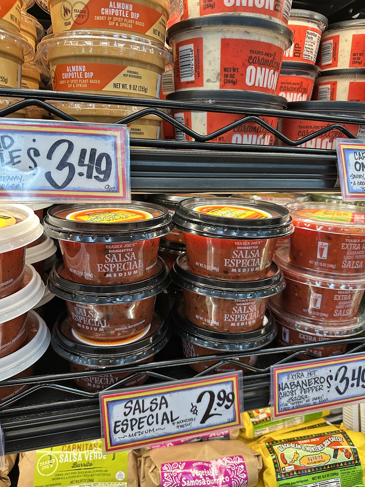 Containers of salsa especial medium in refrigerated case at Trader Joe's.