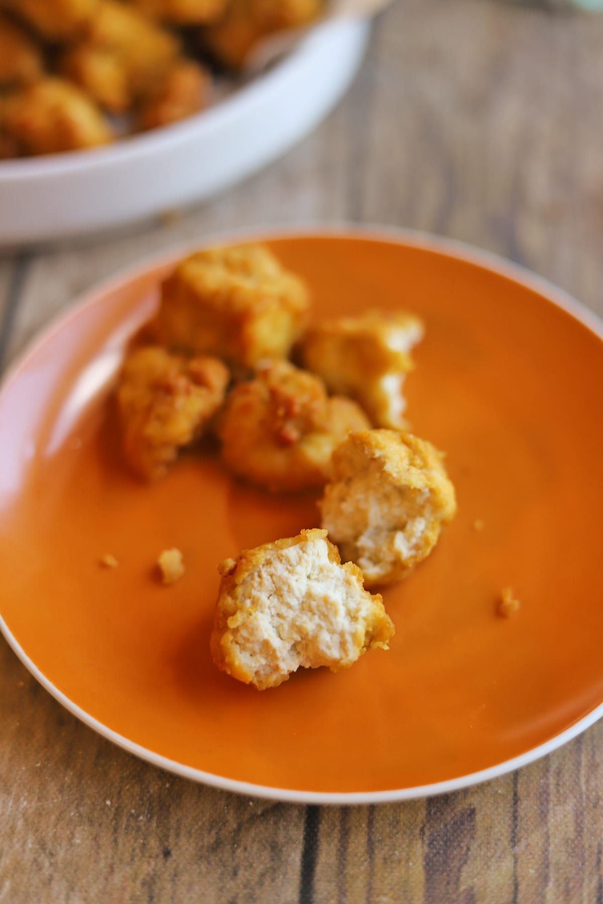 Vegan tofu bites torn in half to show white tofu surrounded by crispy breading.