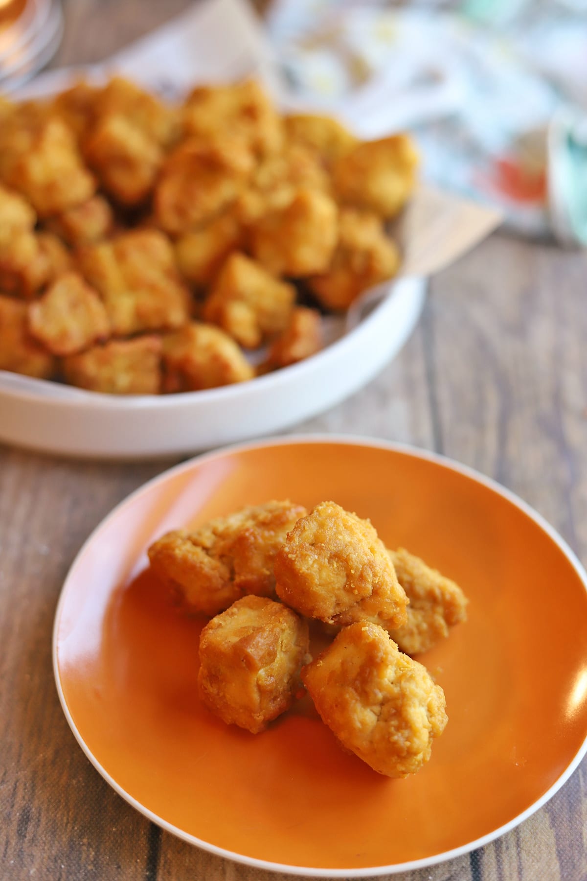 Crispy tofu bites with gluten-free coating on plate and platter.