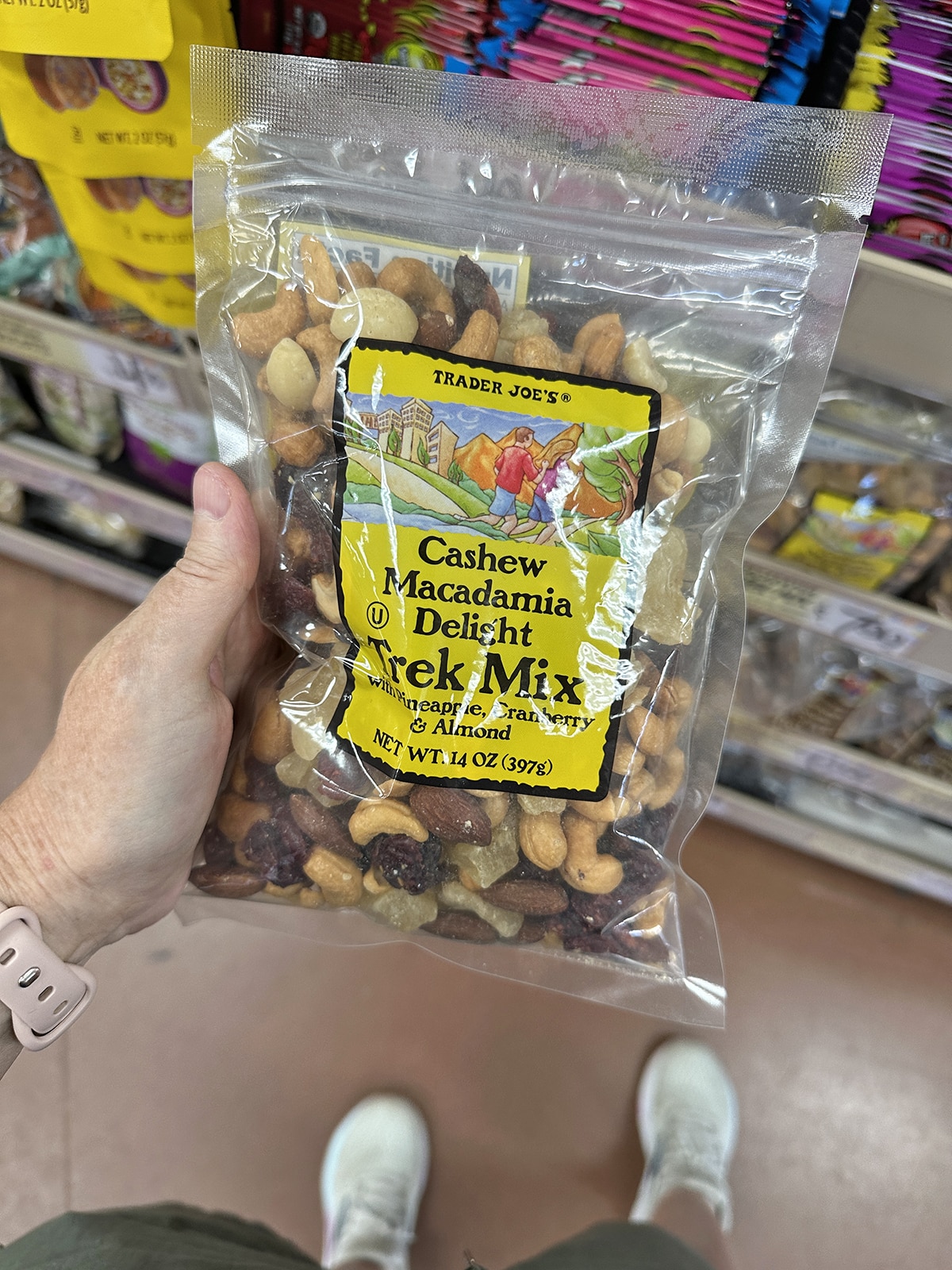 Hand holding cashew macadamia delight trail mix.