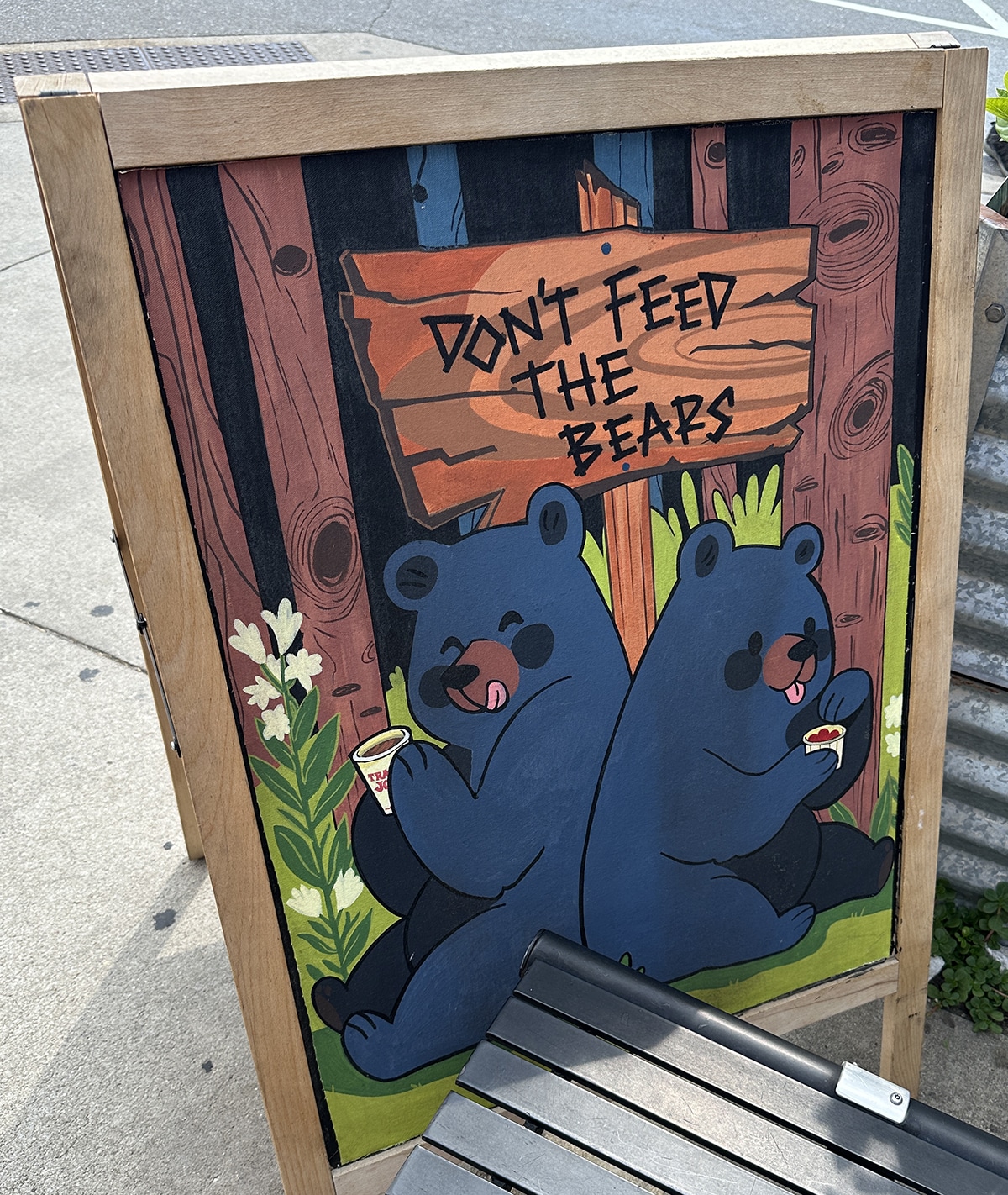 Sign at Trader Joe's with bears eating from Trader Joe's cups and a sign that says, "Don't feed the bears."