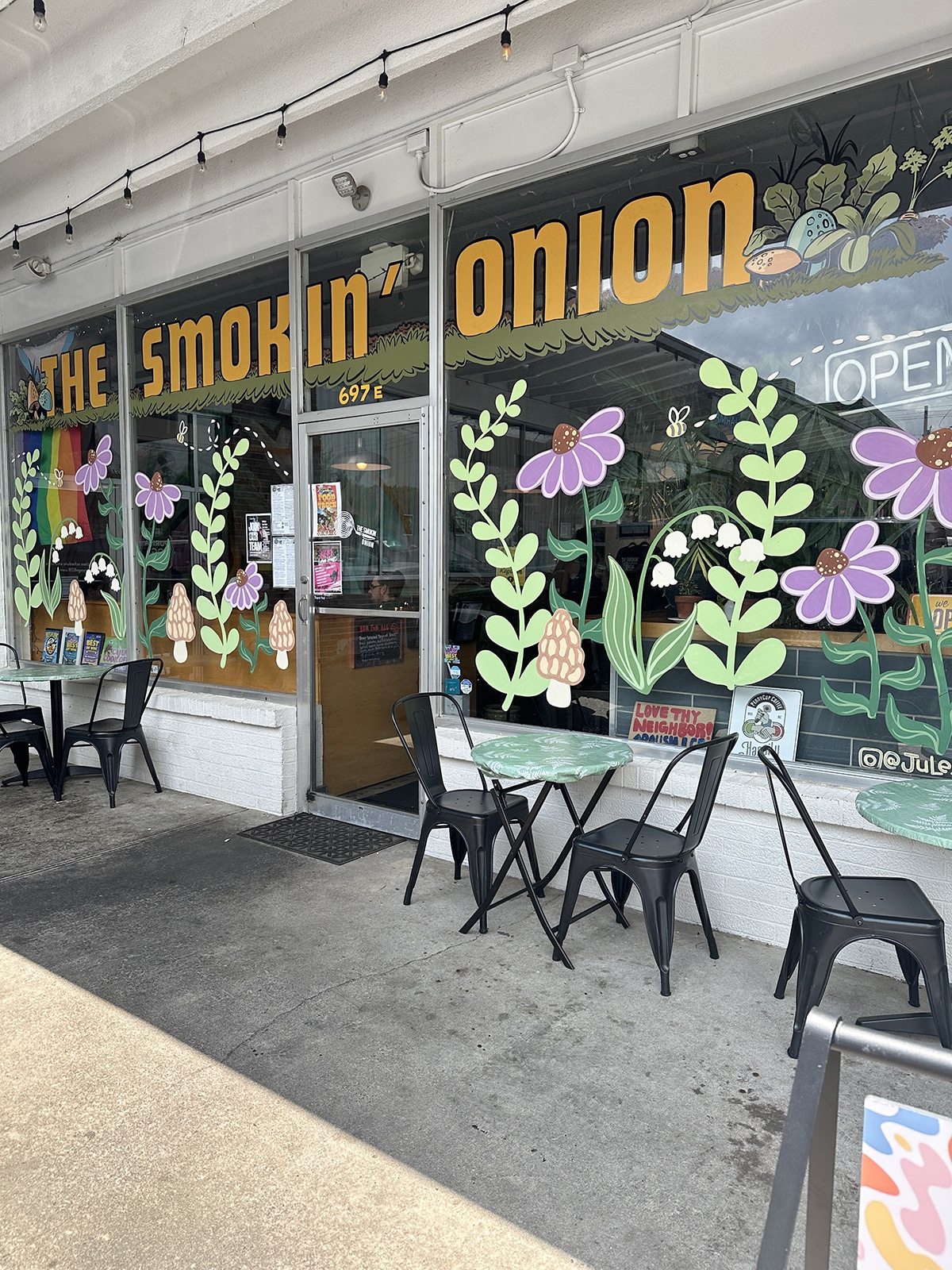 Exterior The Smokin' Onion restaurant with flowers and plants painted on windows.