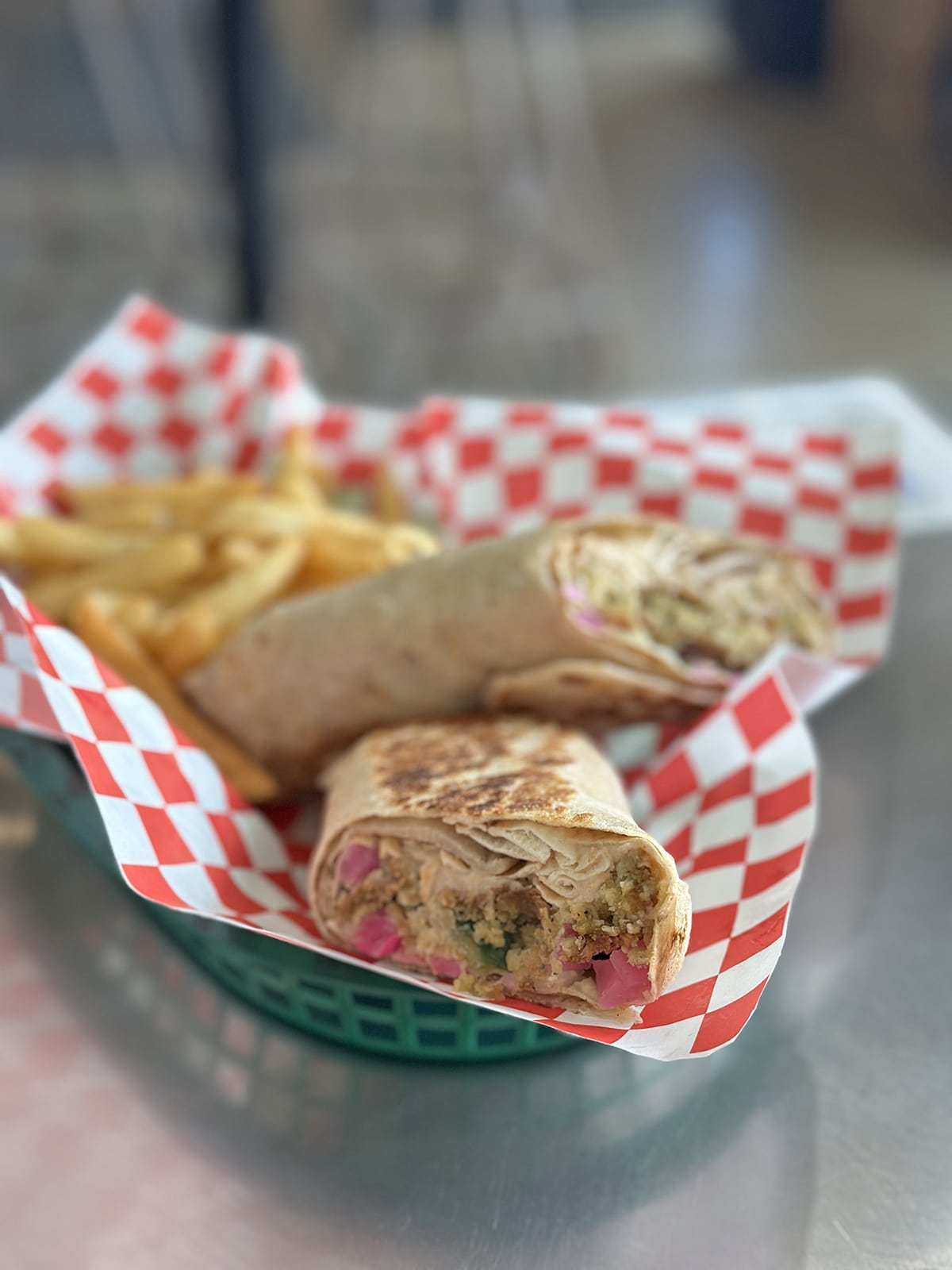 Falafel wrap with pickled turnips and side of fries in basket.