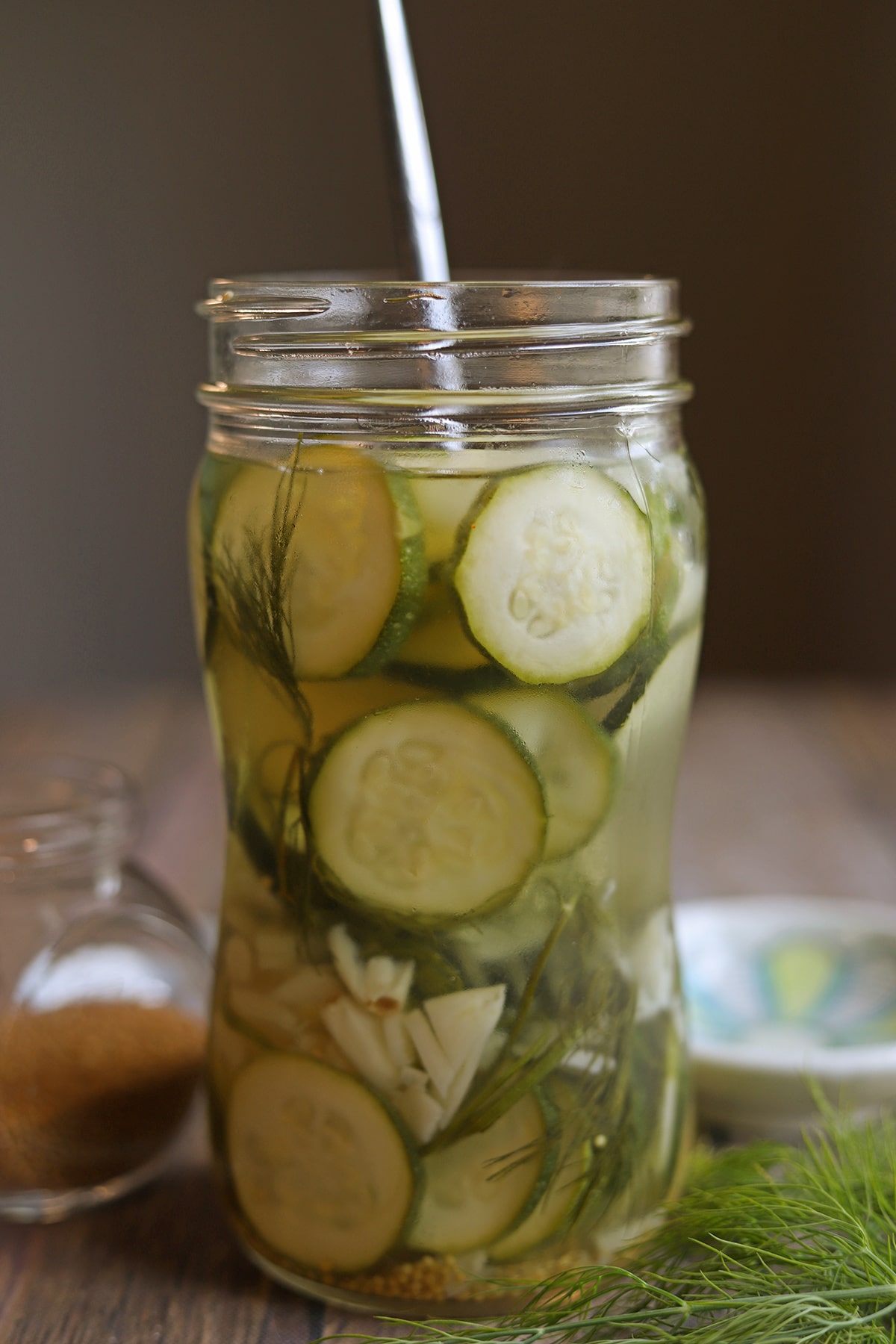 Easy pickled zucchini in jar with dill, garlic, and mustard seeds.
