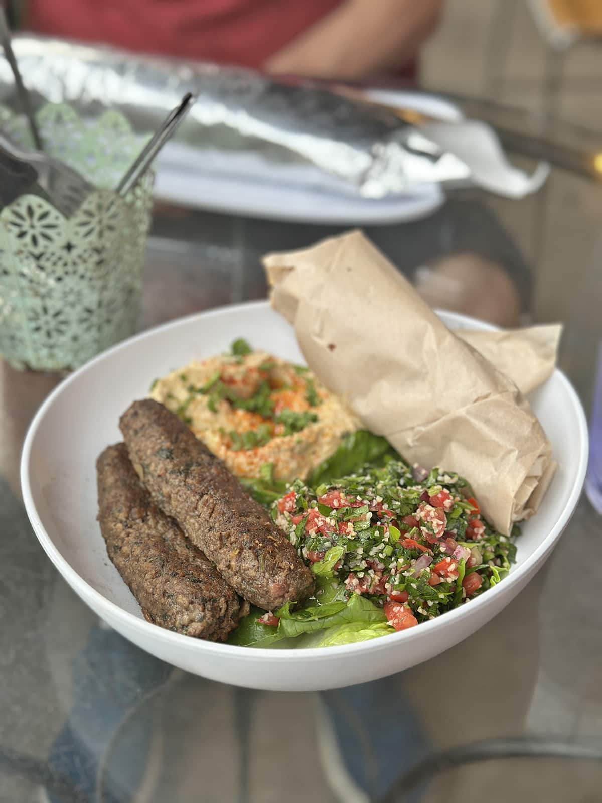 Vegan kofta plate with Impossible kofta, hummus, tabouli, and pita.