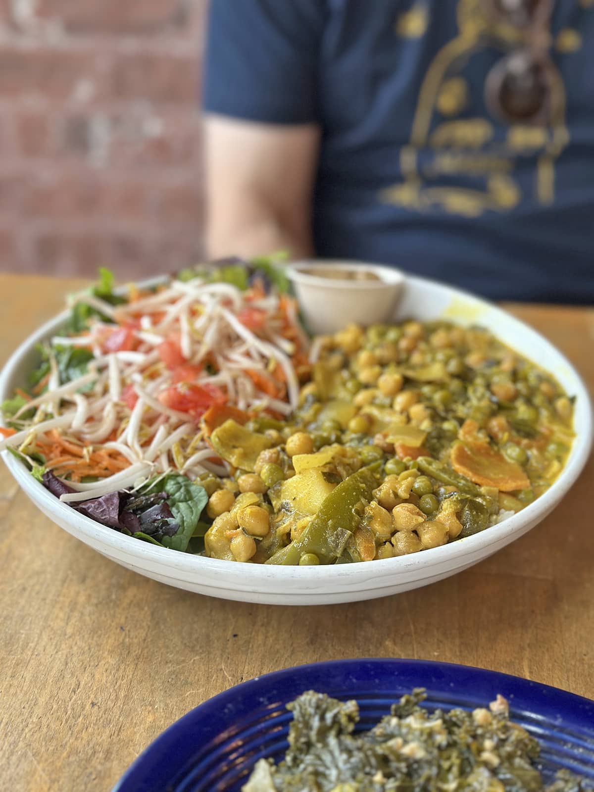 Coconut curry with chickpeas in bowl with salad.