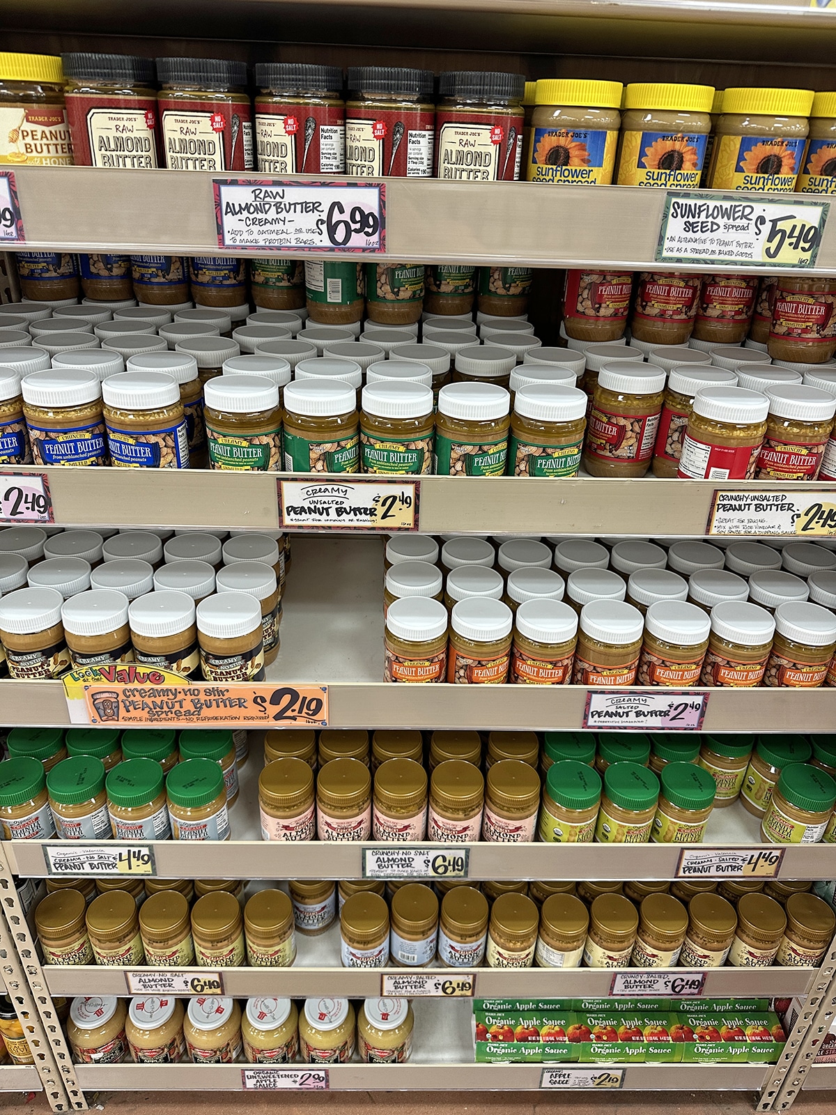 Containers of nut and seed butters on display at Trader Joe's.