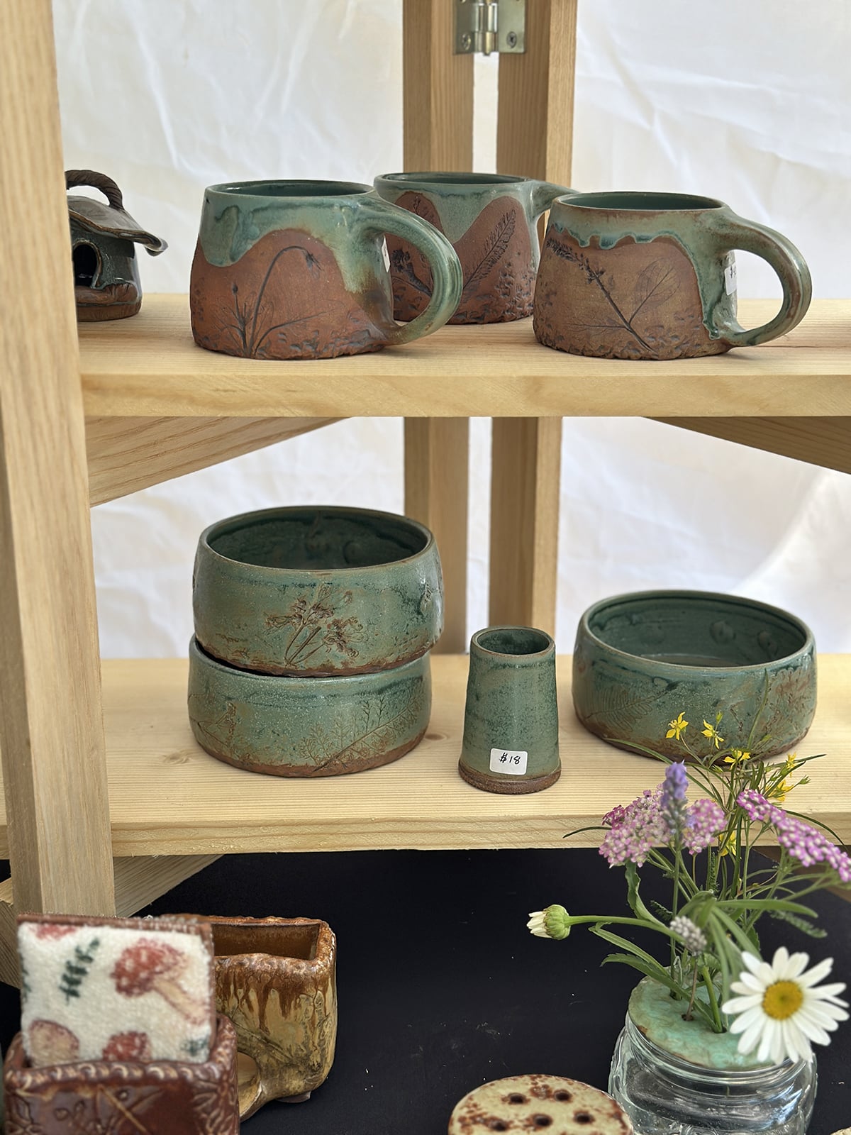 Aqua glazed pottery on display at farmers market.