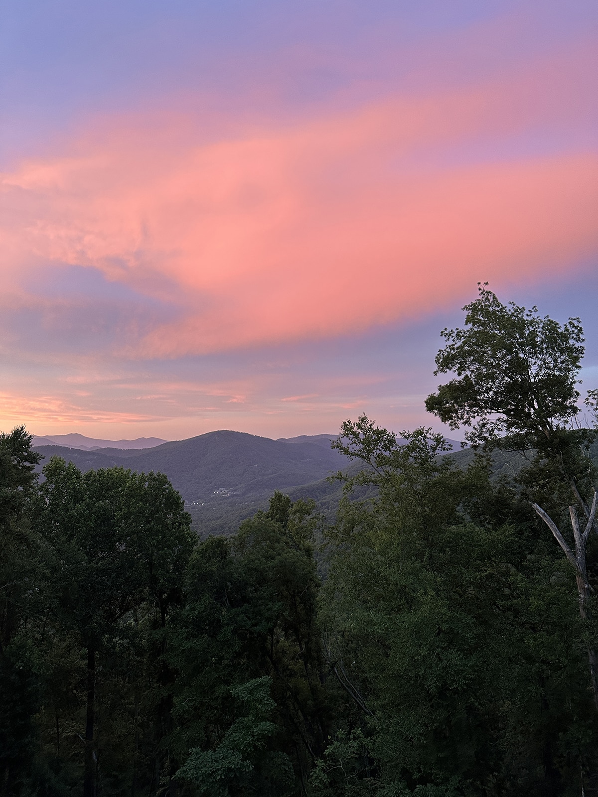 Pink and blue clouds hover over the Blue Ridge Mountains.
