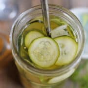 Thinly sliced zucchini in jar with dill and brine.