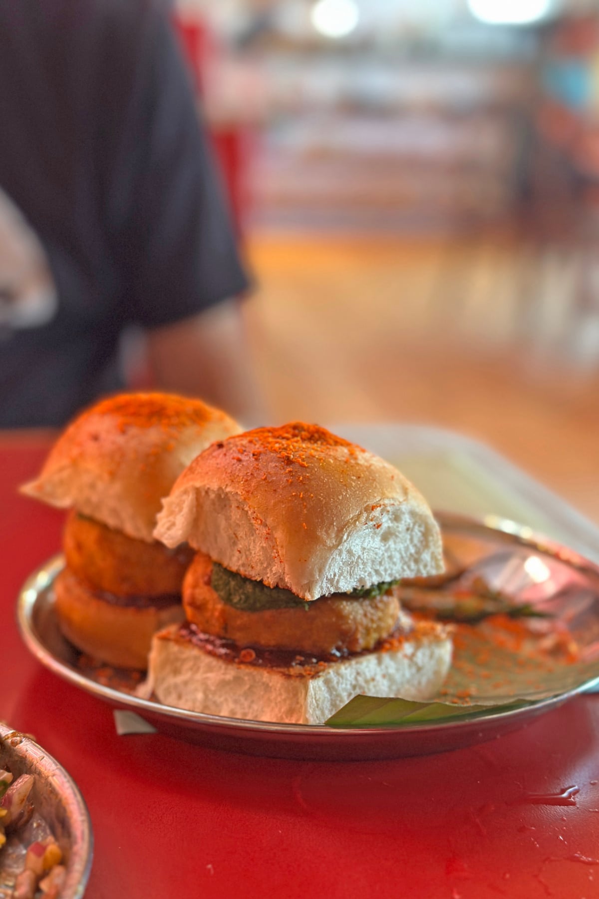 Vada pav filled with spiced potato dumplings fried in curried chickpea batter and topped with mint & tamarind chutneys.