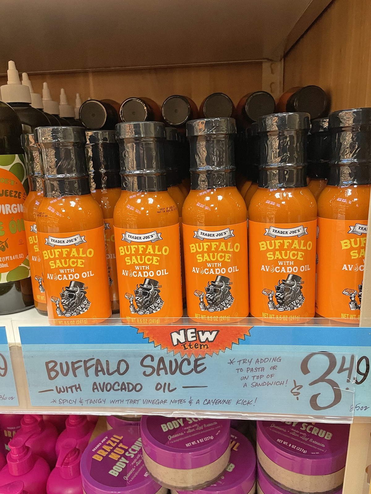 Bottles of buffalo sauce with avocado oil on store shelf.