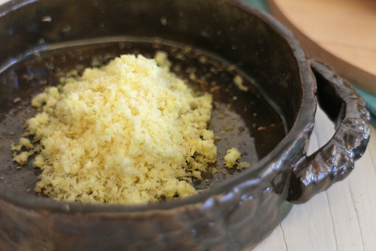 Finely grated ginger root in bowl.