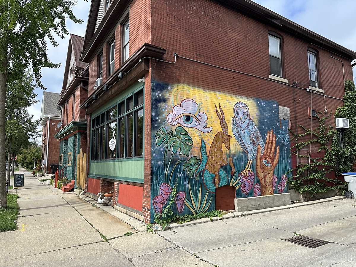 Mural with owl and eyes on the Seven Swans Creperie building.