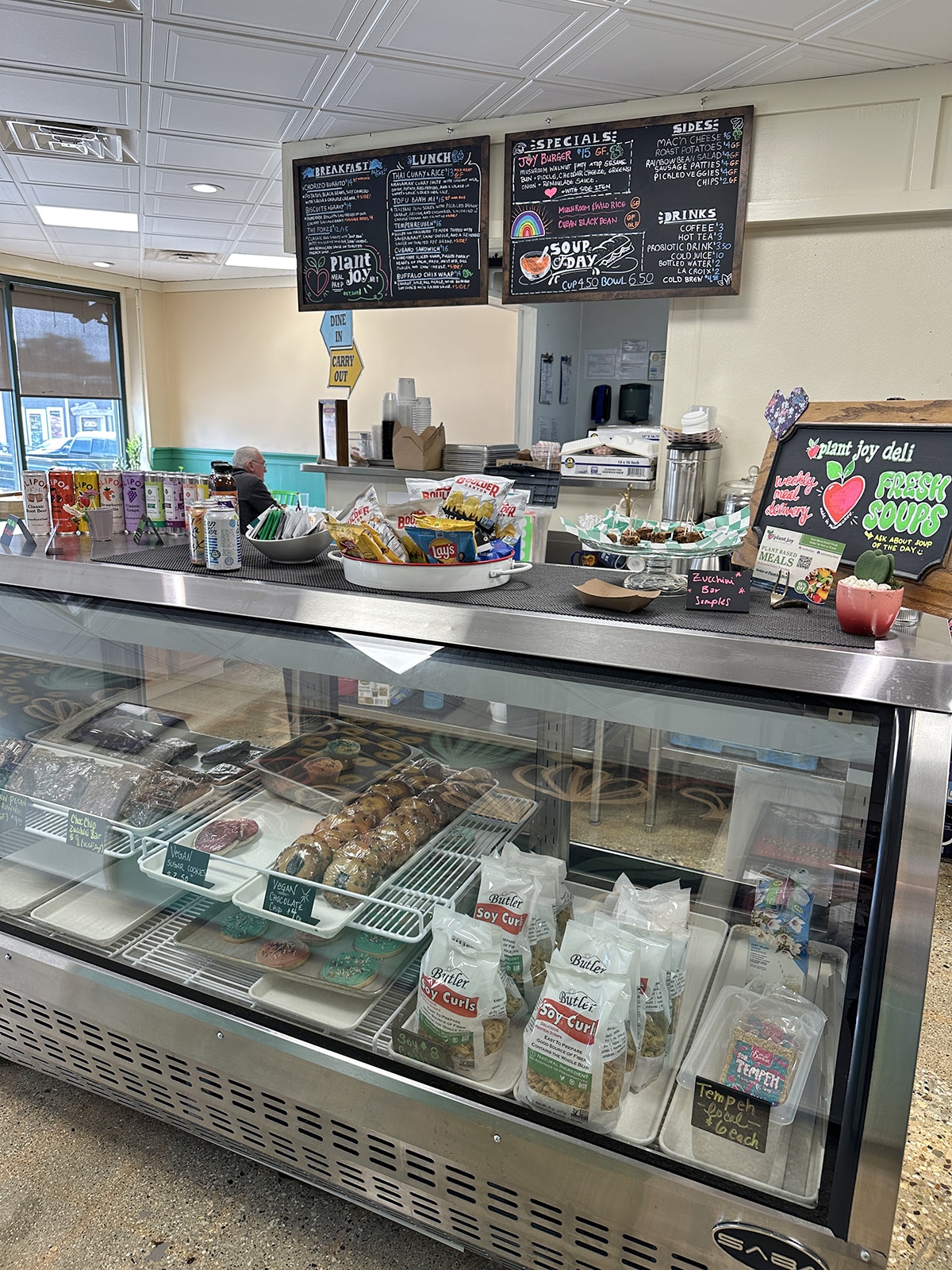 Menu board and sweets on display at Plant Joy Deli.