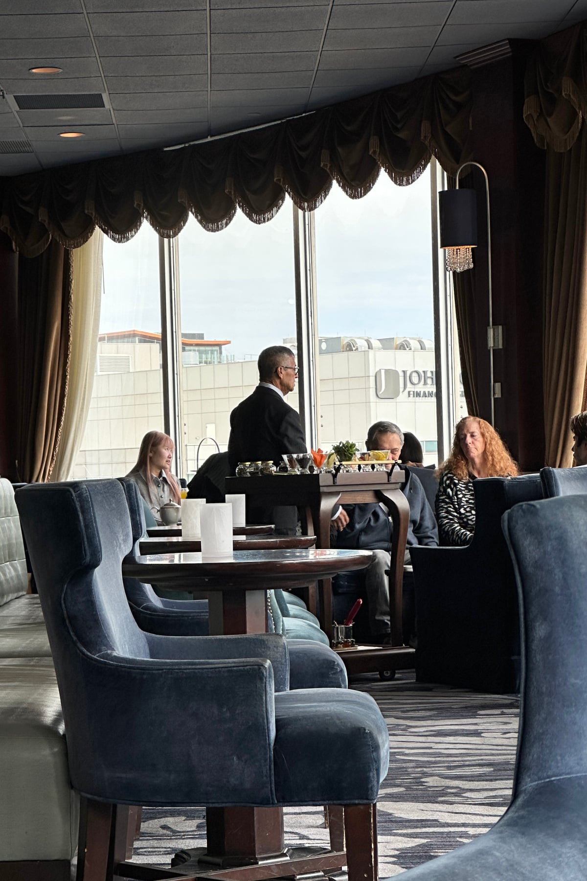 Man in suit at Pfister Hotel leading afternoon tea demonstration.