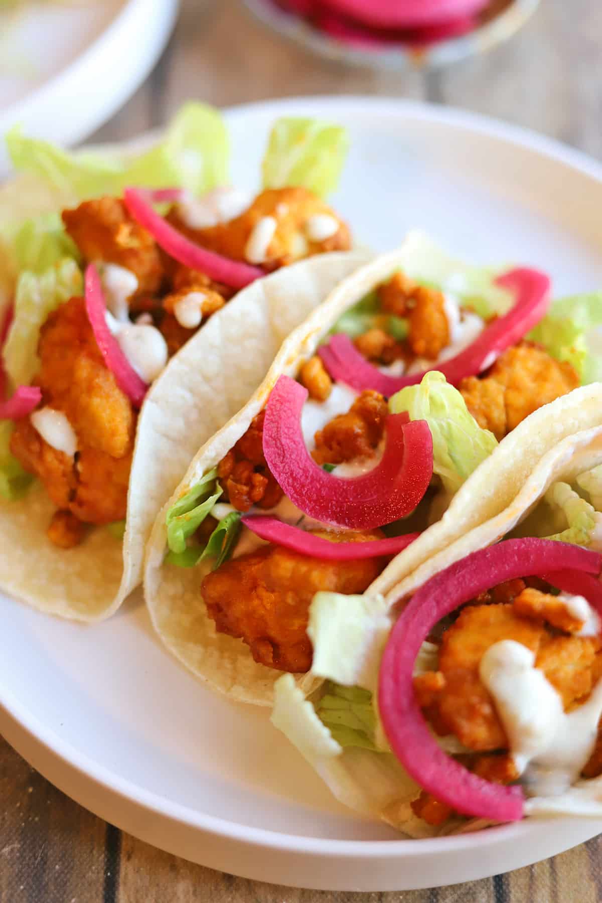 Pickled red onions atop buffalo tofu tacos.